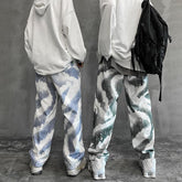 Loose fit streetwear pants with abstract blue and green patterns, white hoodies, sneakers
