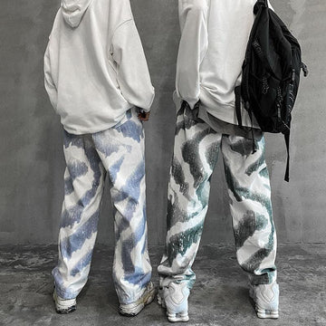 Loose fit streetwear pants with abstract blue and green patterns, white hoodies, sneakers