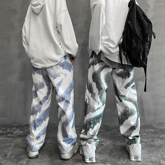 Loose fit streetwear pants with abstract blue and green patterns, white hoodies, sneakers