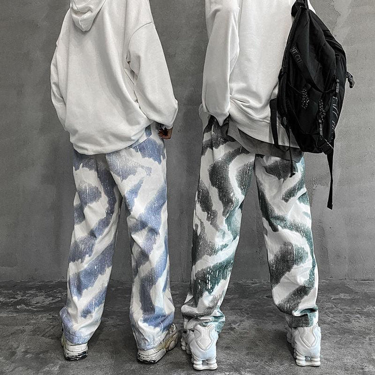Loose fit streetwear pants with abstract blue and green patterns, white hoodies, sneakers