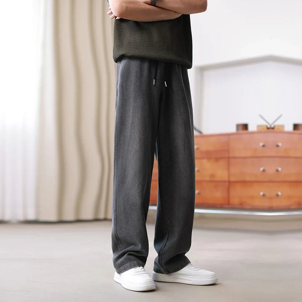 Loose fit dark gray drawstring pants with soft fabric and relaxed streetwear style
