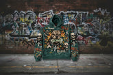 Green streetwear hoodie with bold graphic prints, skulls, crosses, and dog illustration, relaxed fit
