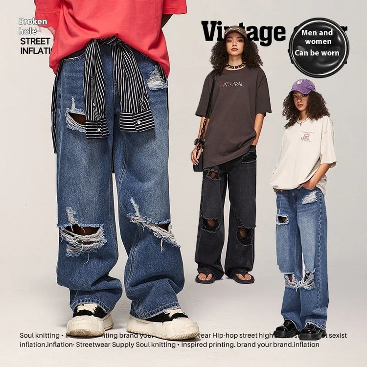 Unisex oversized ripped jeans in blue and black denim, distressed streetwear style, loose fit.