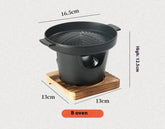 Black cast iron tabletop grill with grooved pan, wooden base, and size measurements displayed.