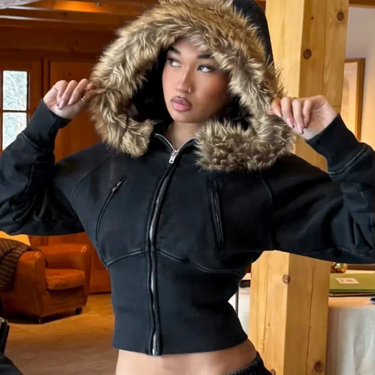 Woman wearing a black cropped zip-up hoodie with faux fur hood, streetwear style