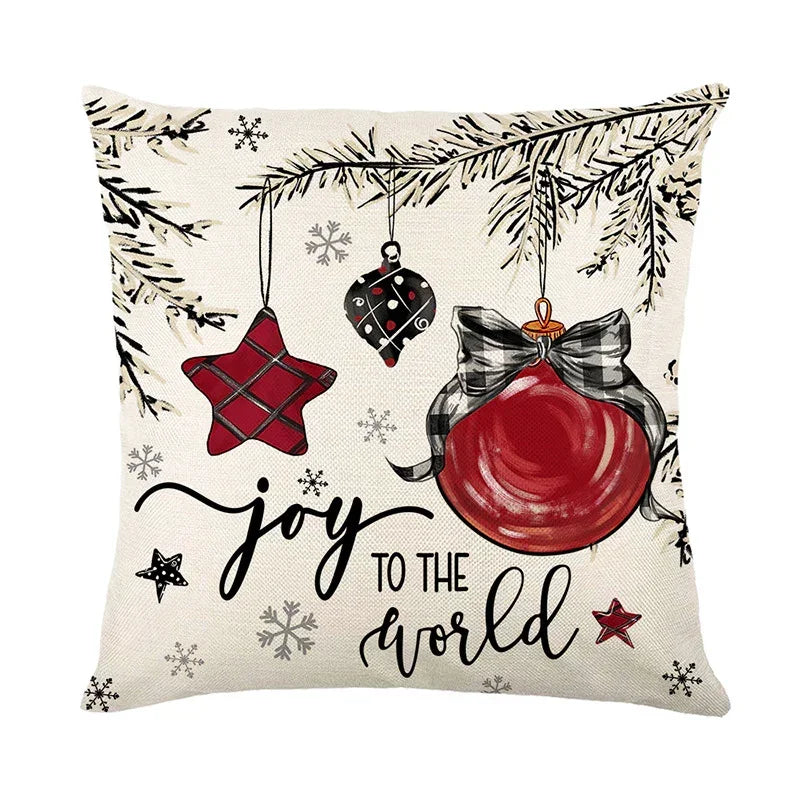 Festive throw pillow with red holiday ornaments, plaid details, and 'Joy to the World' text.