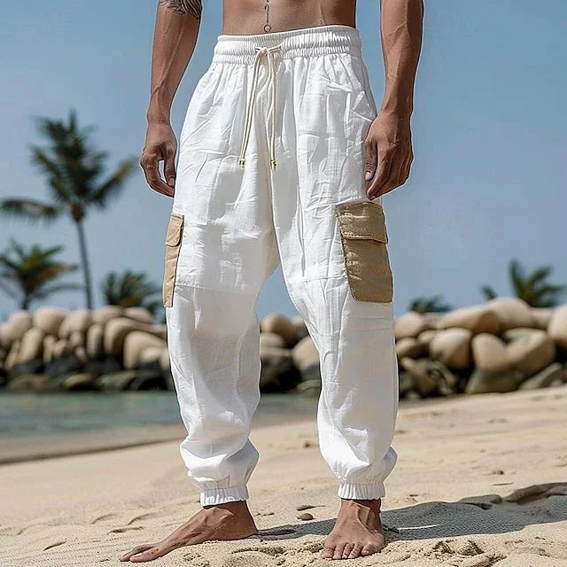 White relaxed-fit cargo pants with beige side pockets, lightweight fabric, beach setting