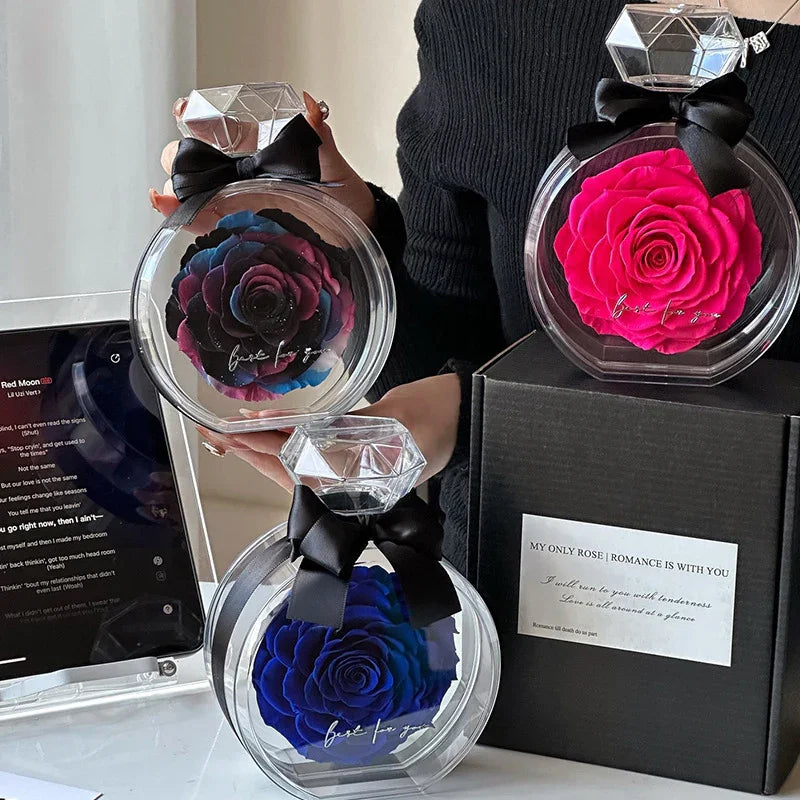 Woman in fitted black ribbed sweater holding colorful artificial roses in clear round cases with diamond-shaped tops and black bows.
