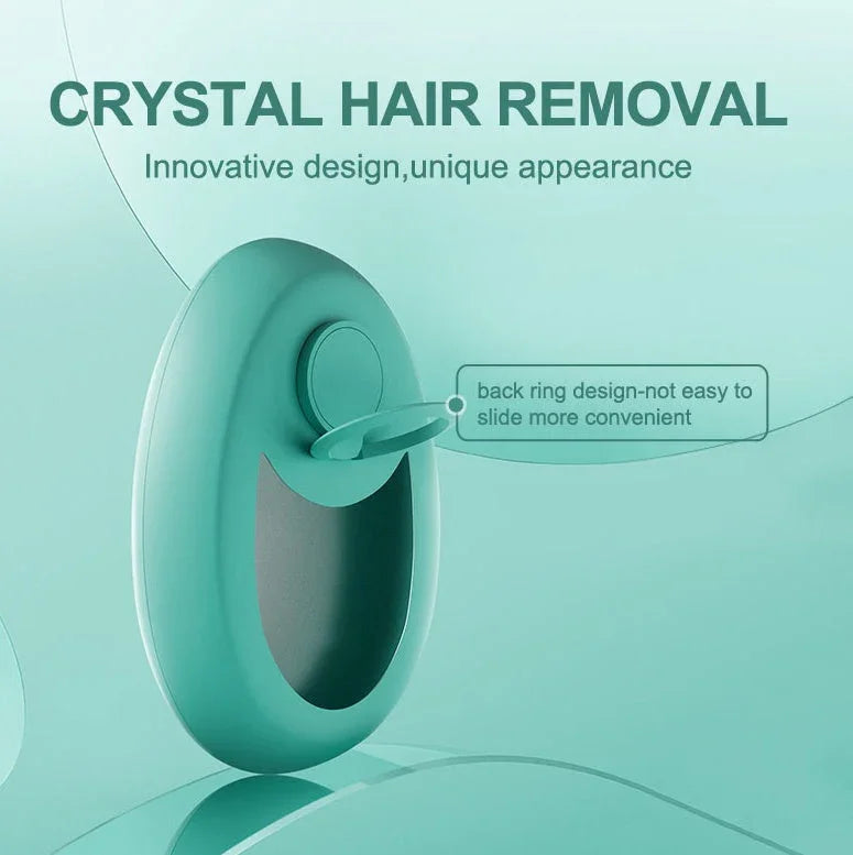 Teal crystal hair remover with ergonomic ring handle and smooth oval design against a light teal background.