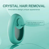 Teal crystal hair remover with ergonomic ring handle and smooth oval design against a light teal background.