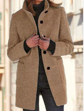 Woman wearing a camel-colored wool coat with black buttons and a tailored fit