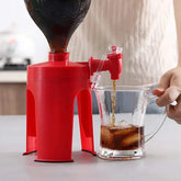 Red plastic beverage dispenser stand pouring soda into clear glass with ice
