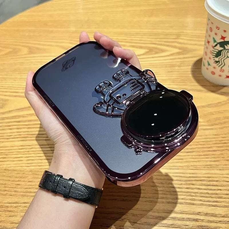 Glossy dark purple phone case with astronaut design, held in hand, modern streetwear style