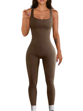Woman wearing a fitted brown ribbed sleeveless jumpsuit with scoop neckline
