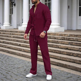 Man wearing a burgundy textured two-piece set with relaxed fit, long sleeves, and white sneakers