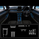 Car interior with black leather seats and dashboard accented by blue trim, showing a full interior trim kit layout below.