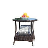 Round brown wicker side table with glass top, fruit bowl, and books on lower shelf