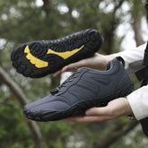 Dark grey low-top athletic sneakers with rugged black and yellow soles, outdoor setting