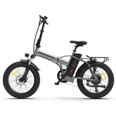 Silver folding electric bike with fat tires, black accents, rear rack, and upright handlebars