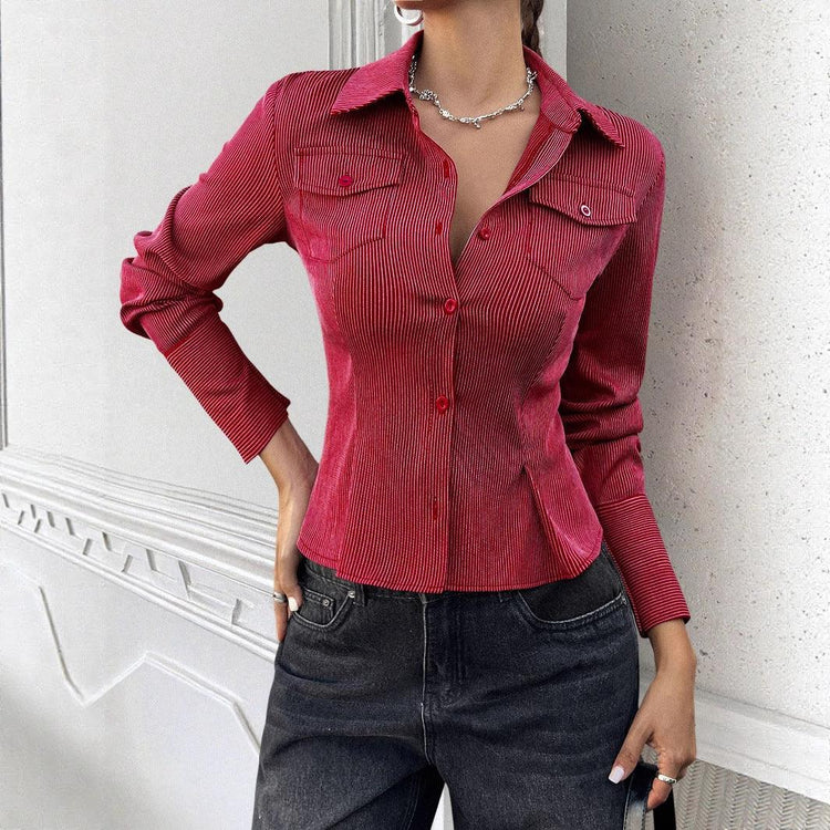 Woman wearing fitted red pinstripe button-up shirt with long sleeves and dark denim jeans