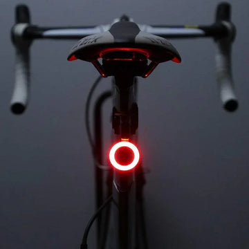 Bicycle with a red LED rear light, black and white frame, road bike handlebars