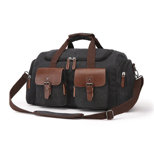 Black canvas duffel bag with brown leather accents, adjustable strap, and front pockets