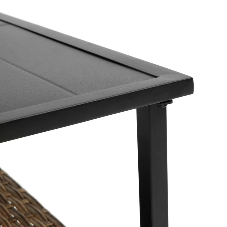 Close-up of modern black metal and wood table corner with woven detail underneath