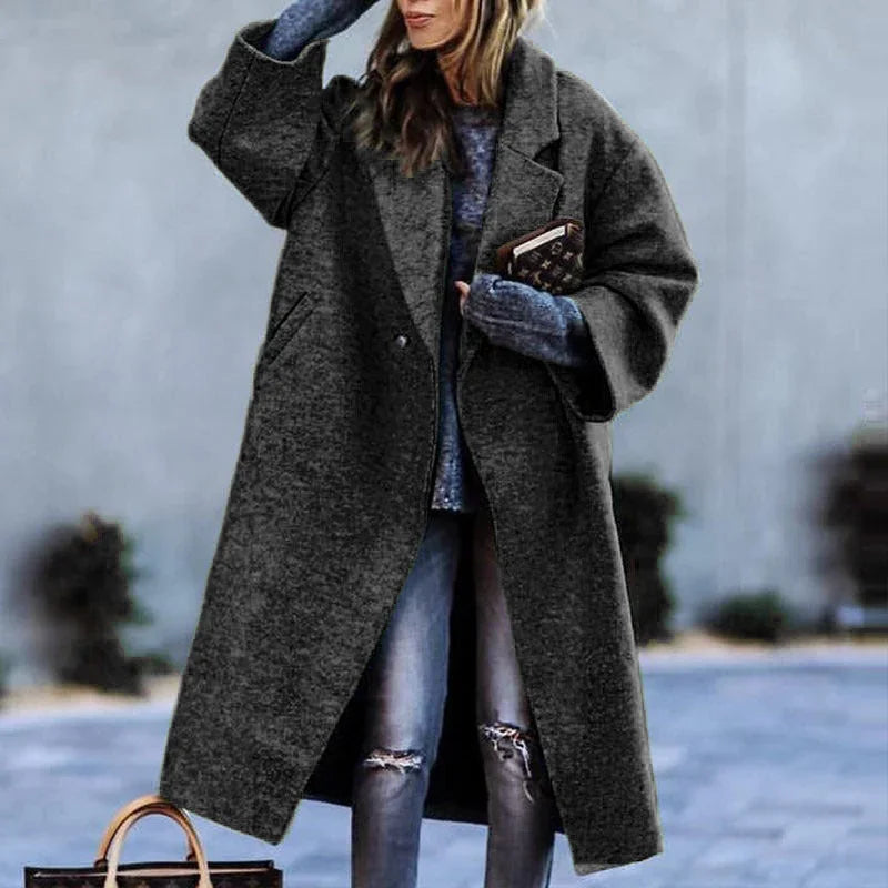 Oversized dark gray wool coat, relaxed fit, paired with casual ripped jeans.