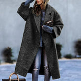 Oversized dark gray wool coat, relaxed fit, paired with casual ripped jeans.