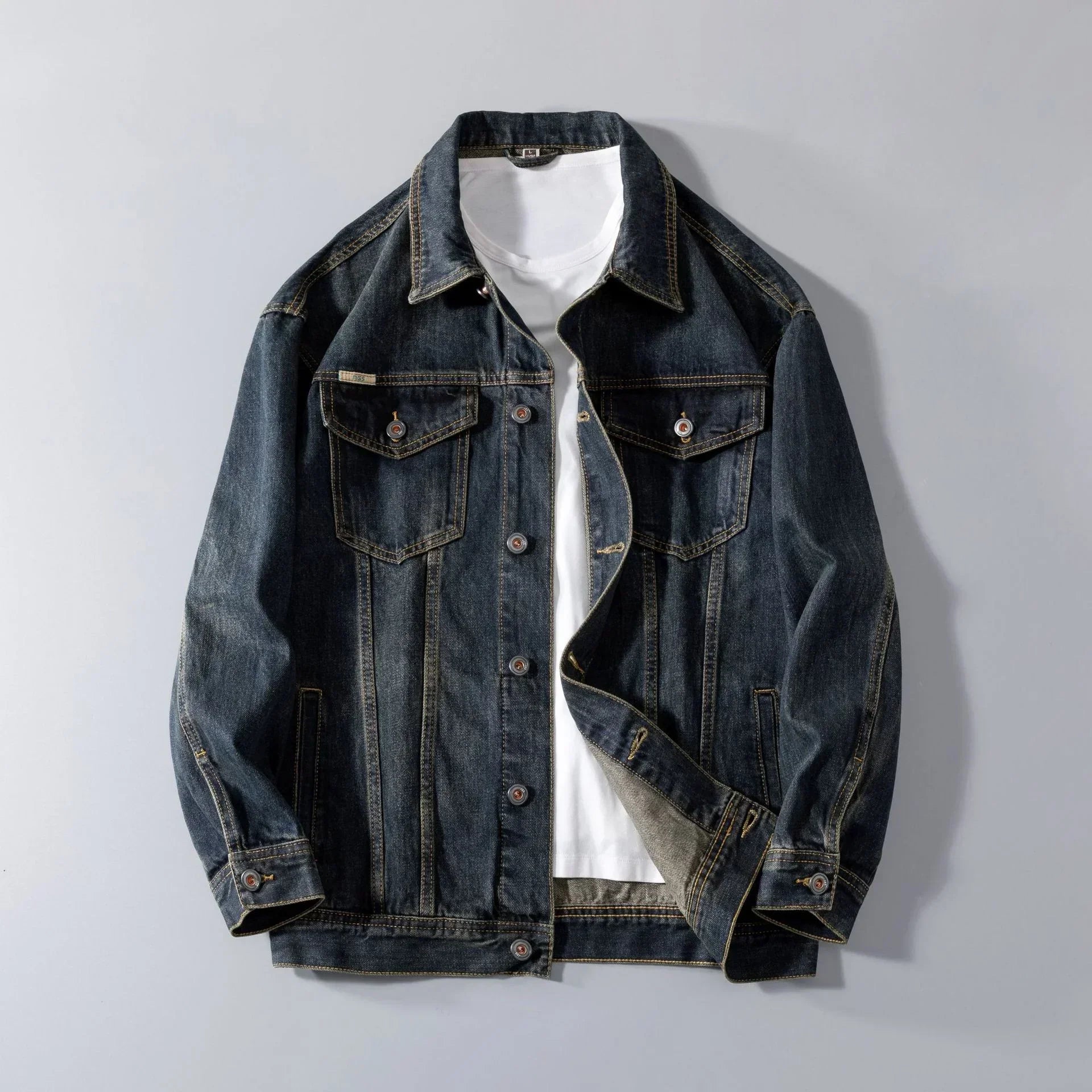 Dark blue denim jacket with button front, chest pockets, relaxed fit over white t-shirt