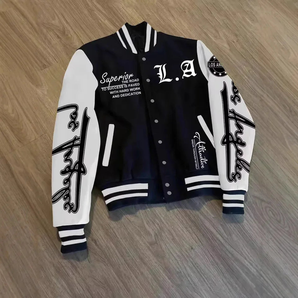 Black and white varsity jacket with Los Angeles script, bold lettering, and relaxed fit on wood floor.