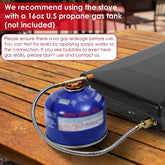 16oz blue propane gas tank connected to portable black stove with metal hose on wooden table