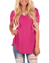 Woman wearing a loose fit hot pink V-neck t-shirt and distressed denim jeans