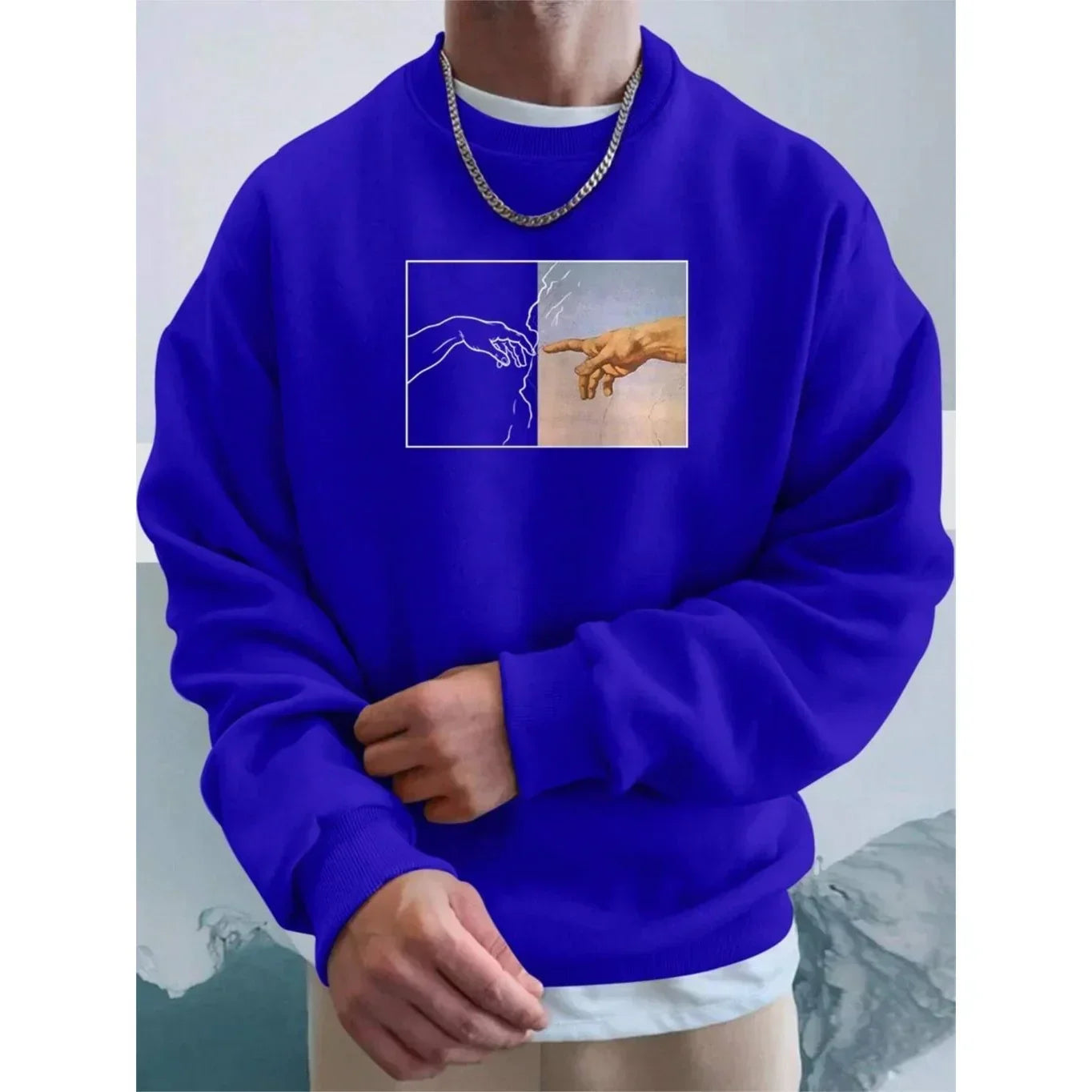 Man wearing blue oversized sweatshirt with graphic hand print, casual fit, cotton material
