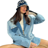 Woman in oversized light blue denim jacket, knit bucket hat, and cream turtleneck sweater