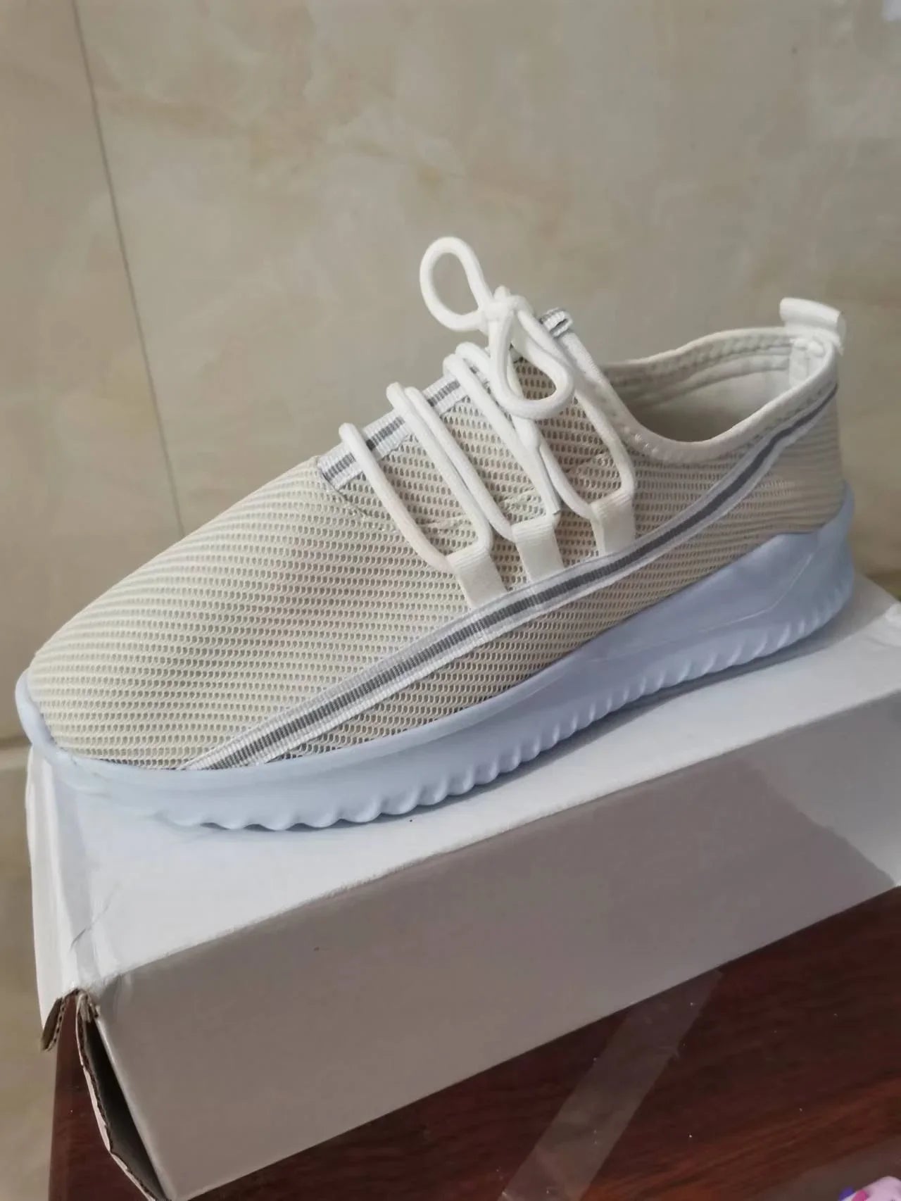 Beige mesh slip-on sneaker with white laces and thick lightweight sole, casual fit