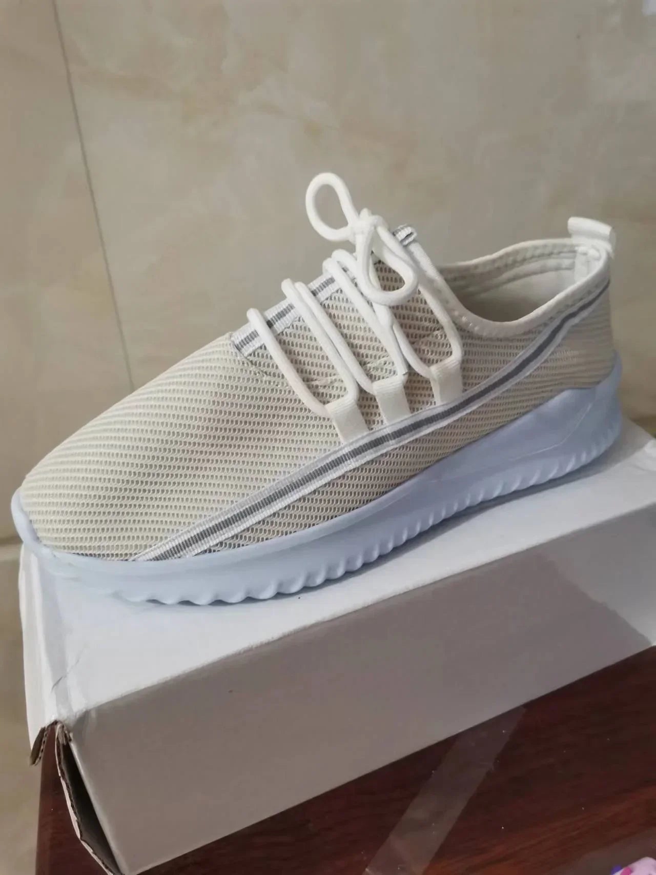 Beige mesh slip-on sneaker with white laces and thick lightweight sole, casual fit