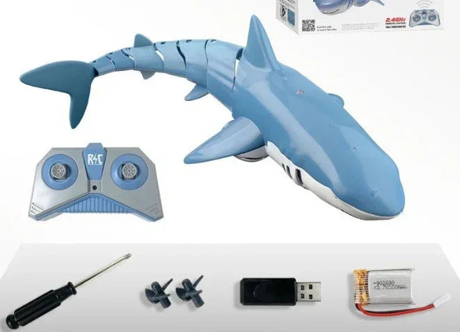 Blue remote control shark toy set with controller, screwdriver, propellers, USB charger, and battery.