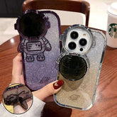 Glittery astronaut-shaped phone cases in purple and silver with hard plastic material.