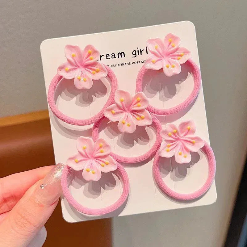 Set of pink fabric hair ties with soft cherry blossom flower accents, feminine style
