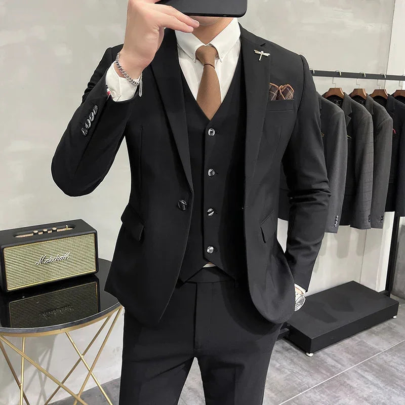 Slim fit black suit with matching vest, white dress shirt, brown tie, and pocket square
