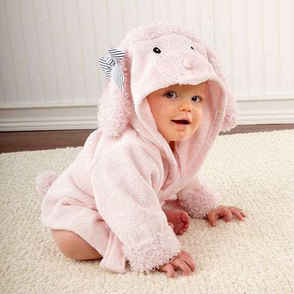 Baby in soft pink hooded animal romper with fluffy ears and a bow, cozy fit on carpet