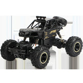 Black off-road RC truck with rugged tires, gold accents, and exposed suspension details