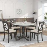 Round marble dining table with four cushioned wooden chairs in modern kitchen