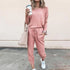 Woman wearing a pink lounge set with drawstring joggers, relaxed fit, and white sneakers