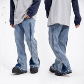 Baggy light blue denim jeans with side zippers and raw hem, streetwear style