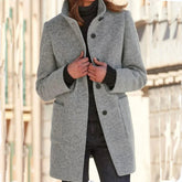 Woman wearing a light gray wool coat with button closure and relaxed fit over a black sweater