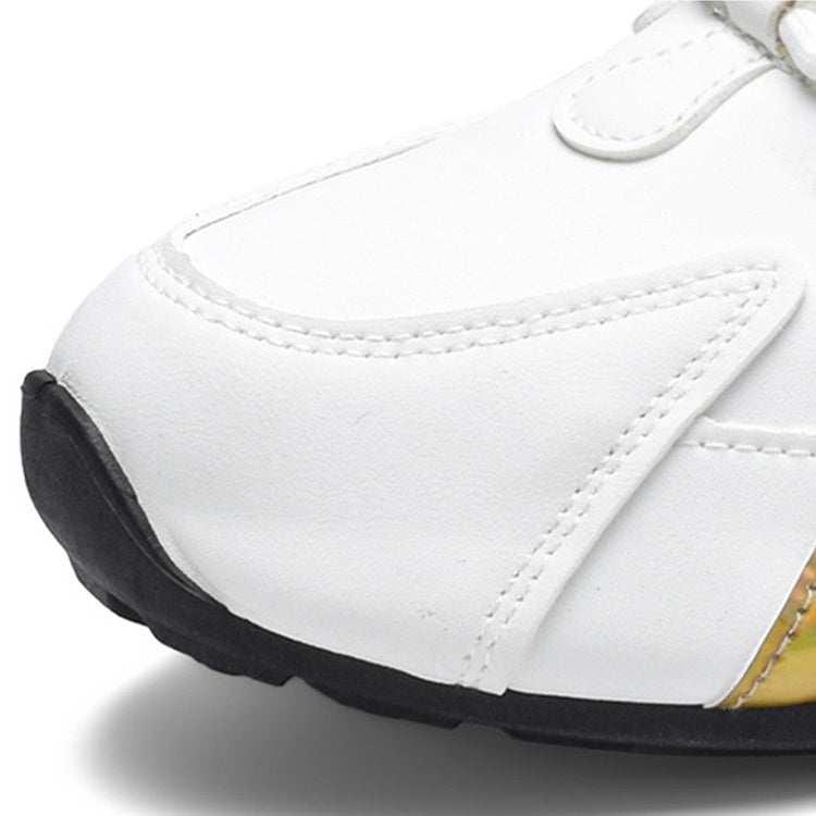 Close-up of white synthetic sneaker with black sole and gold accent, modern streetwear style