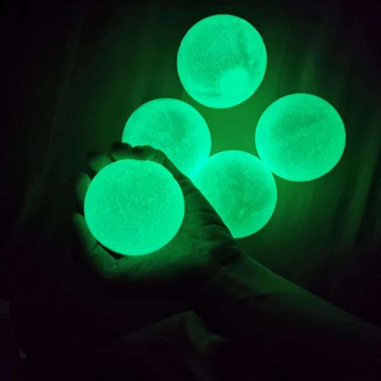 Hand holding glow in the dark green balls, smooth texture, spherical shape, luminous decor