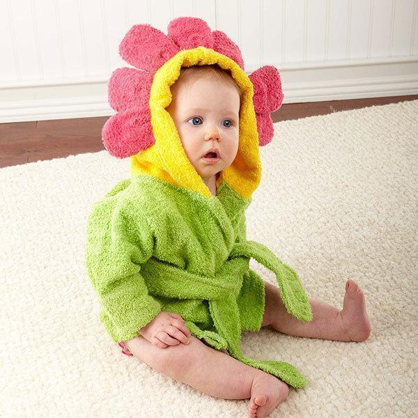 Baby in green terry robe with hood featuring yellow and pink flower petals, relaxed fit
